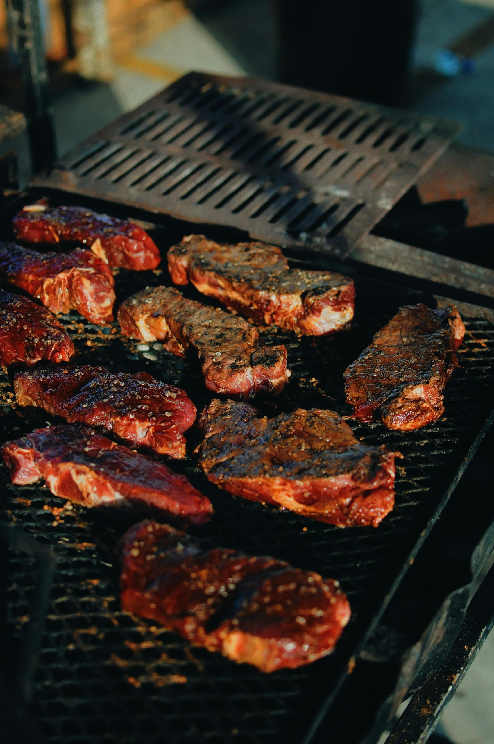 Sizzling steaks on a charcoal grill, perfect for a backyard BBQ.